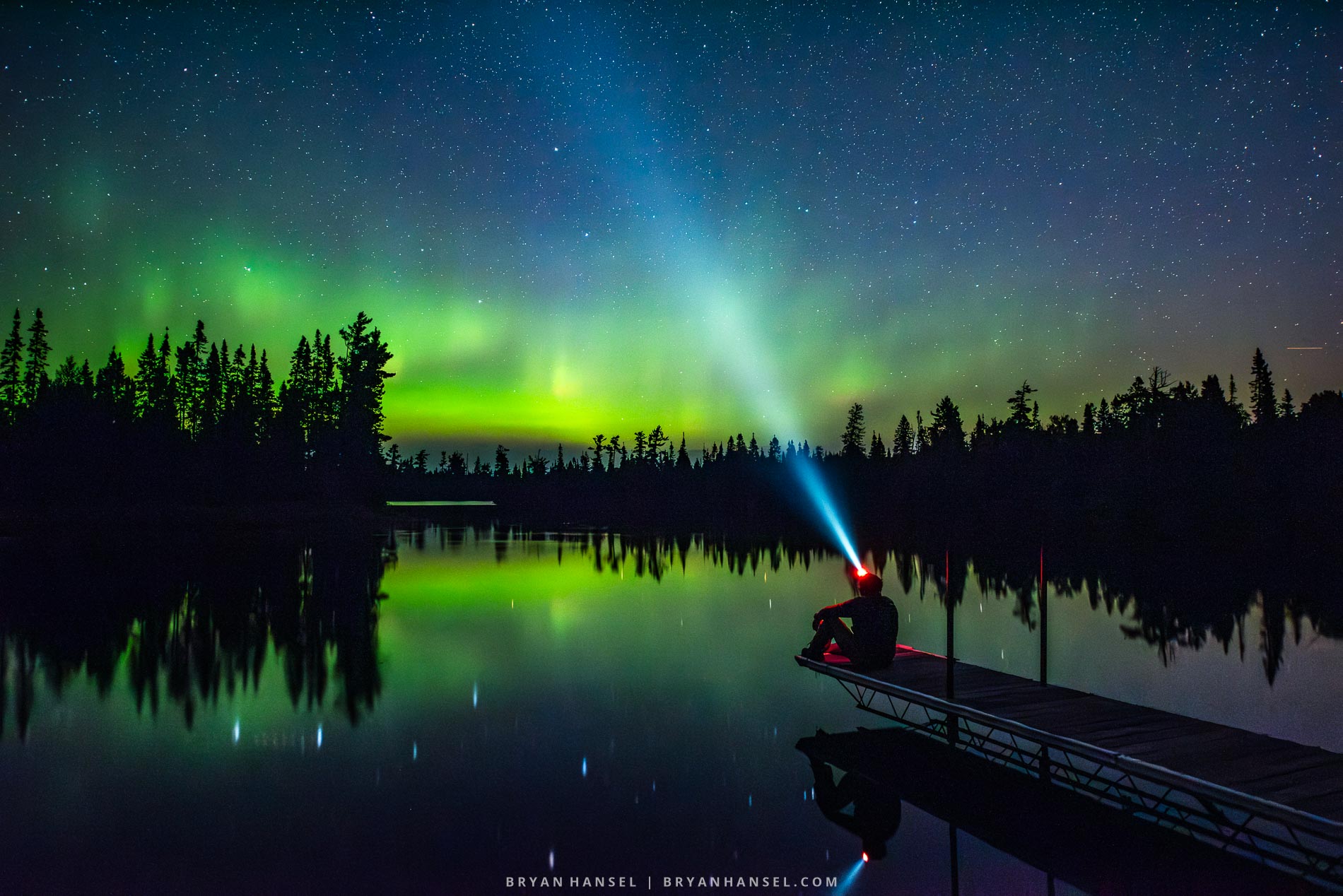 A photo workshop participant being photographed under the northern lights near Grand Marais.